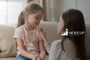 A frowning little girl, comforted by her mom
