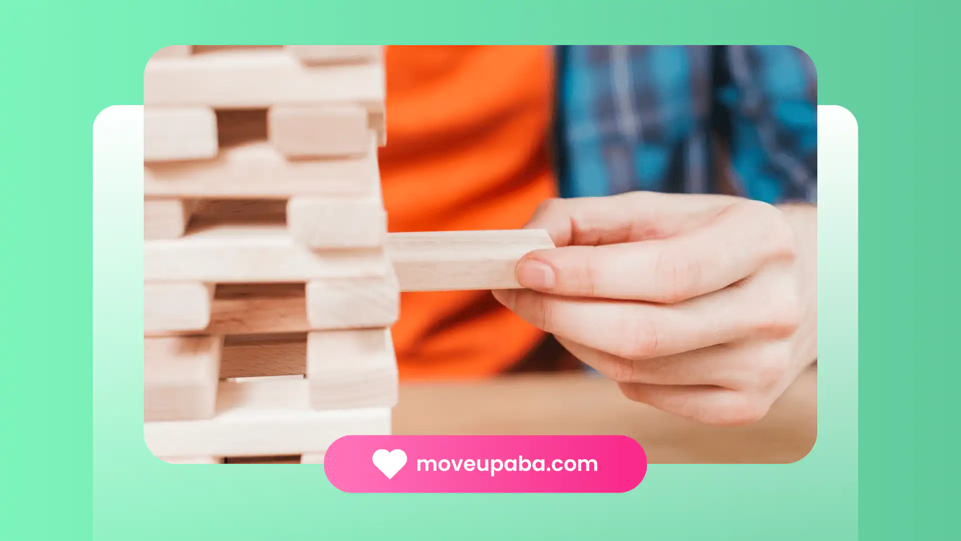 An autistic adult pulling a Jengga block.