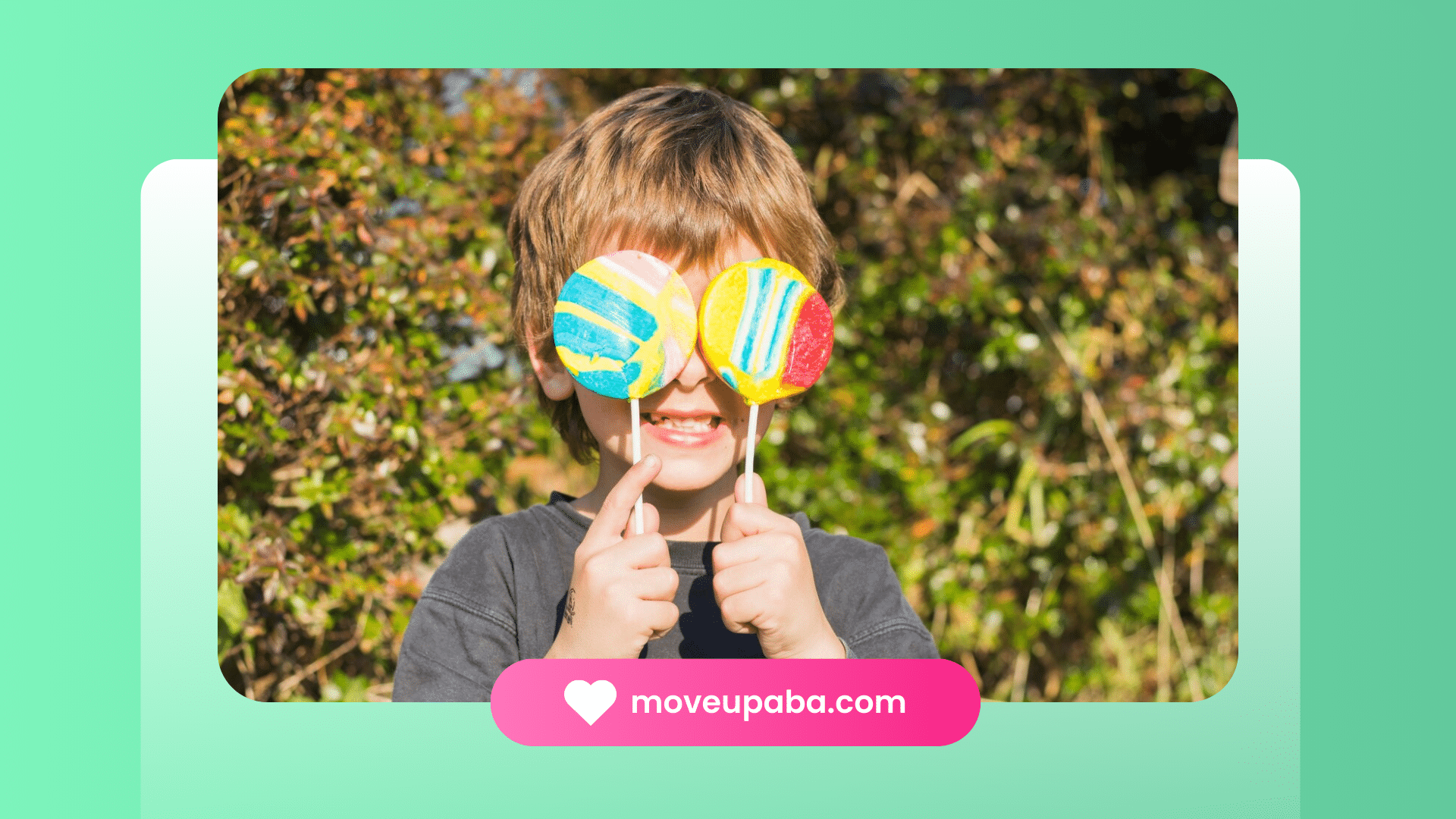 A boy holding up two lollipops in front of his face.
