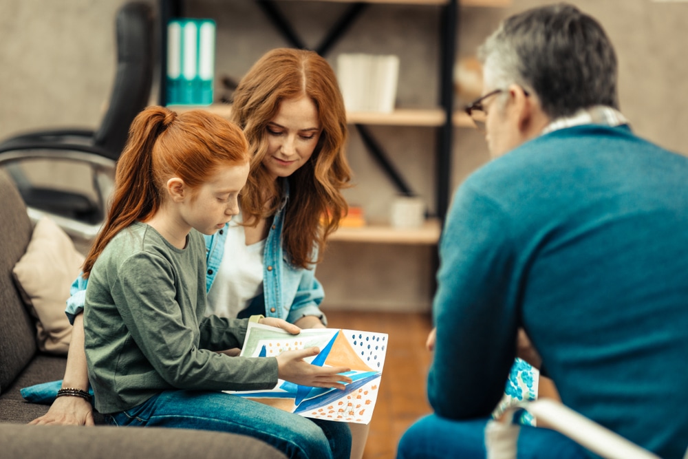 A child receives behavioral support for autistic children using educational materials.