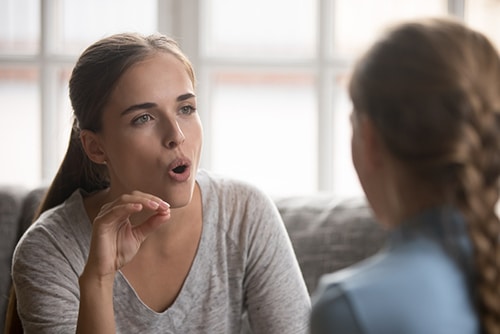 A therapist is engaging a child, likely during Autism behavioral therapy.