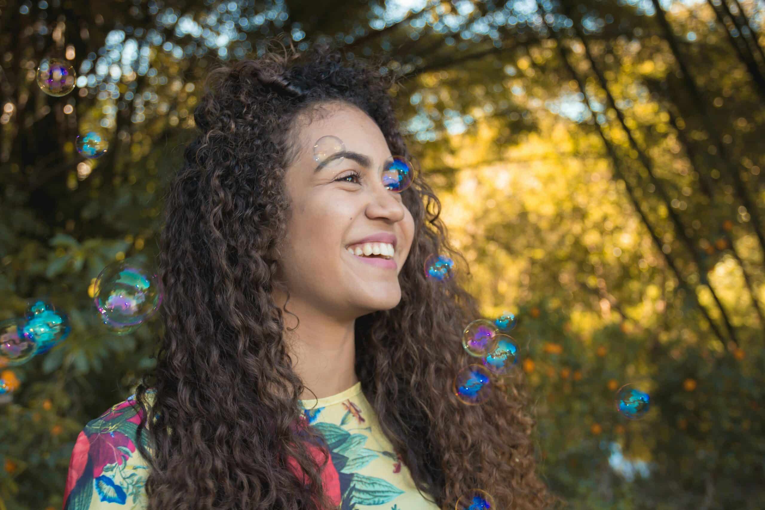 autistic woman smiling at floating bubbles