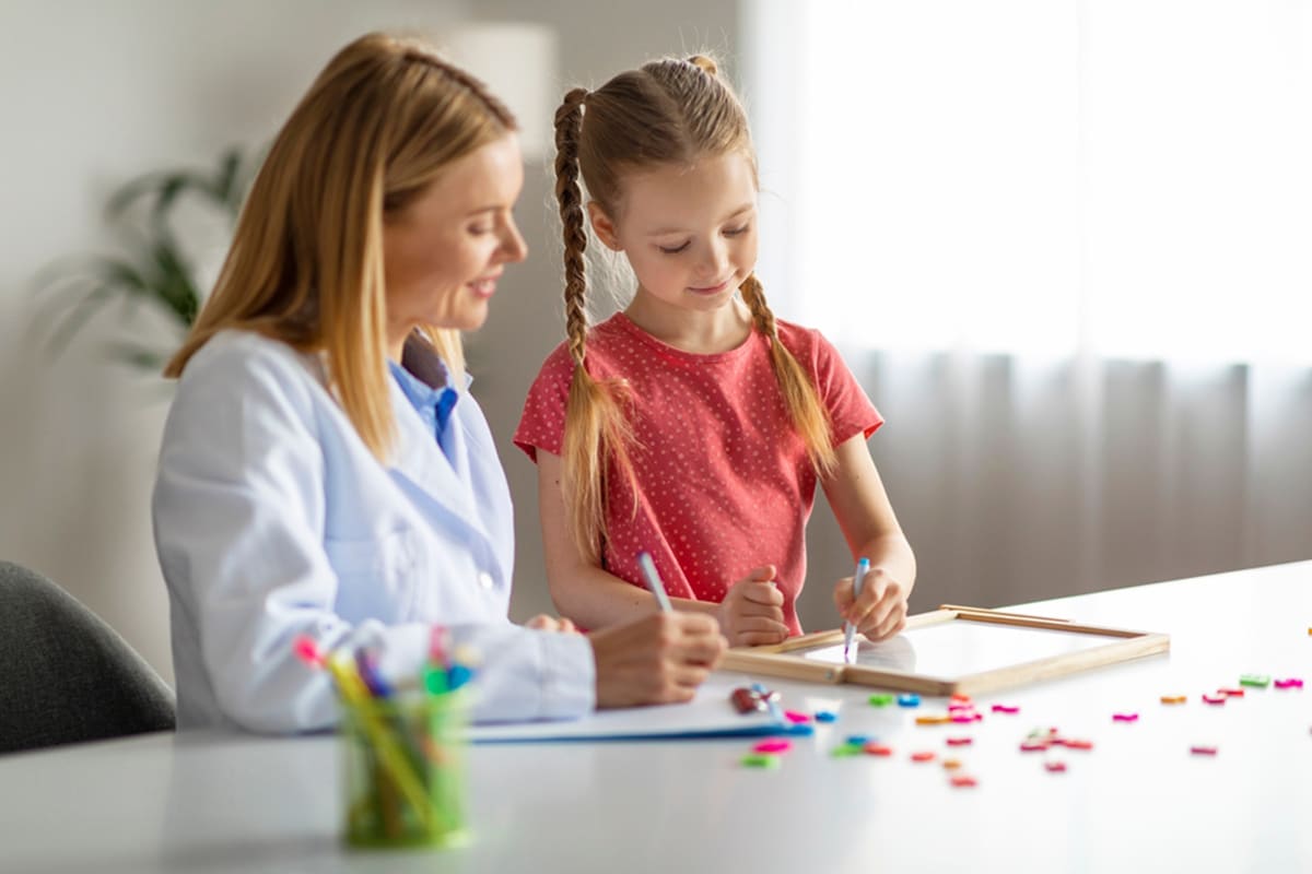 An ABA therapist engaging with a young girl in a center-based therapy session