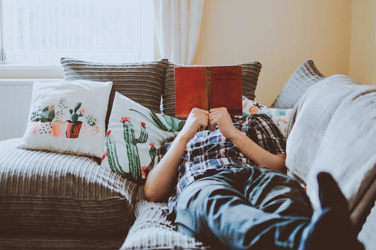 man reading a book on the couch