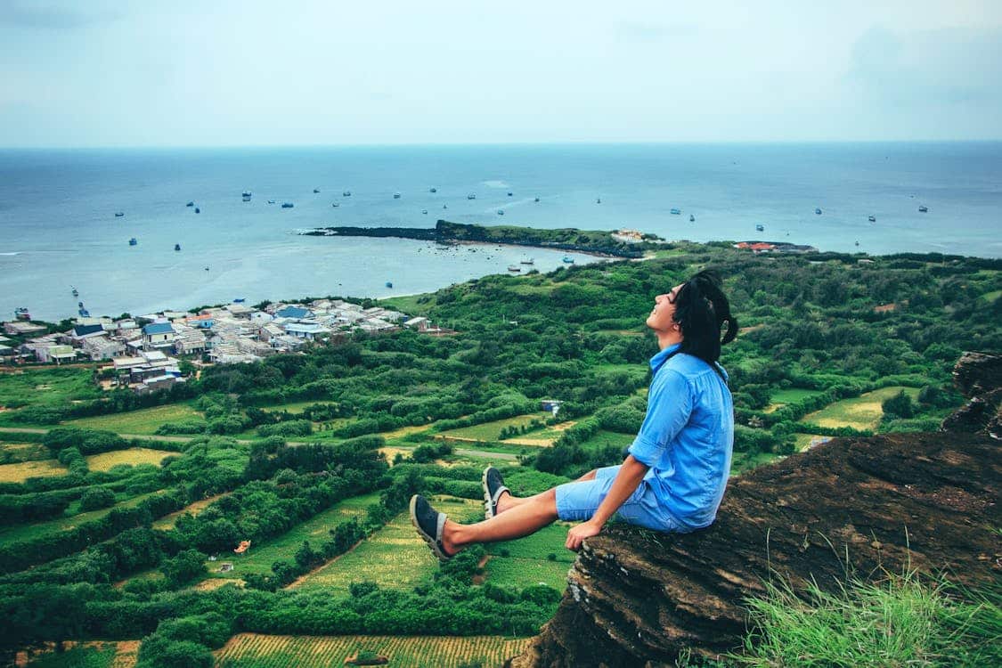 teenager at the edge of a cliff laughing