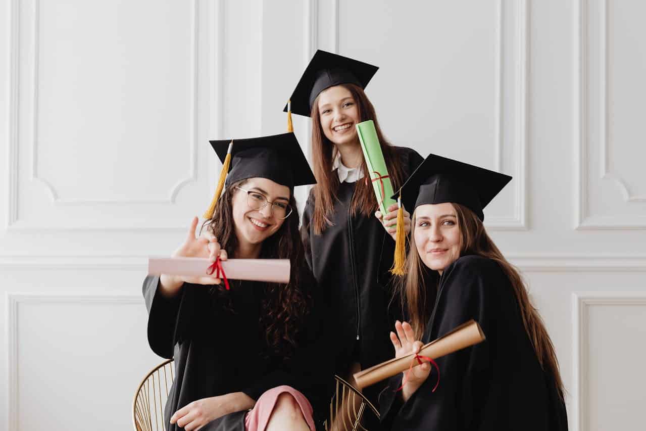 3 female graduates smiling at the camera for ABA therapy