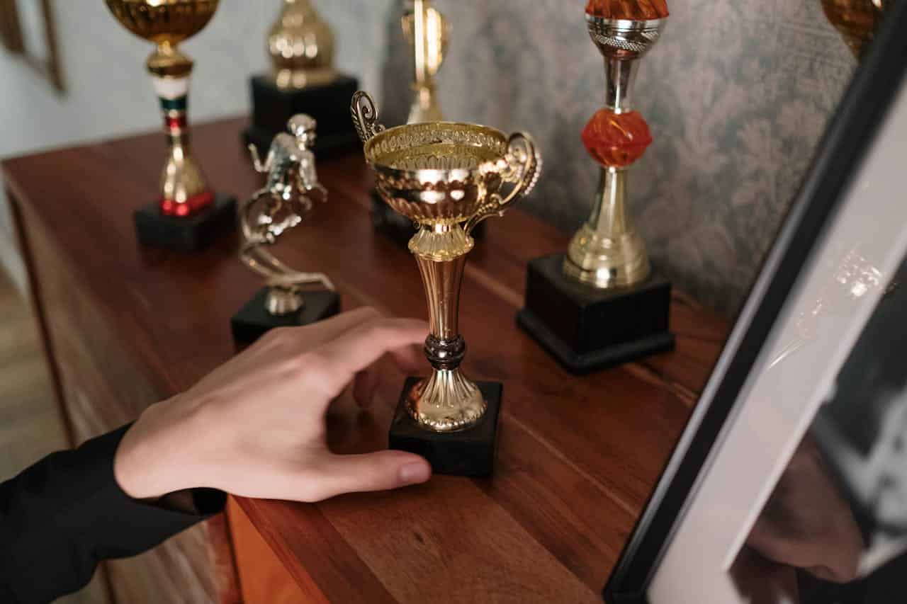 hand putting a trophy on the shelf