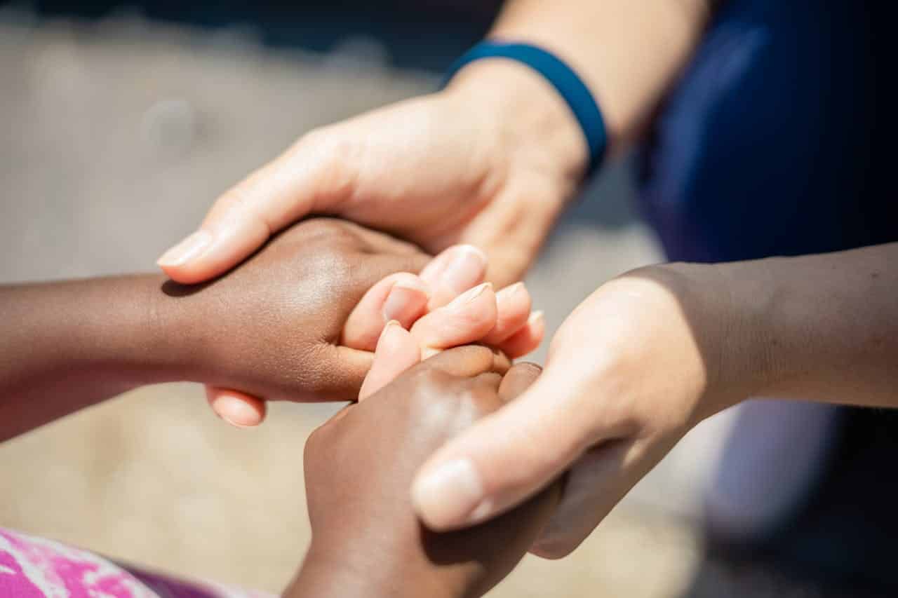 parent gently holding autistic child's hands