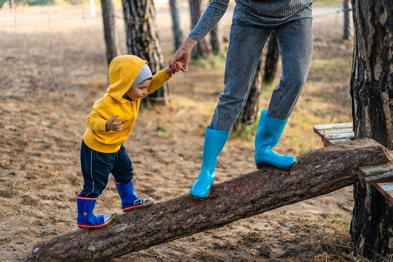 parent helping her kid up a tree