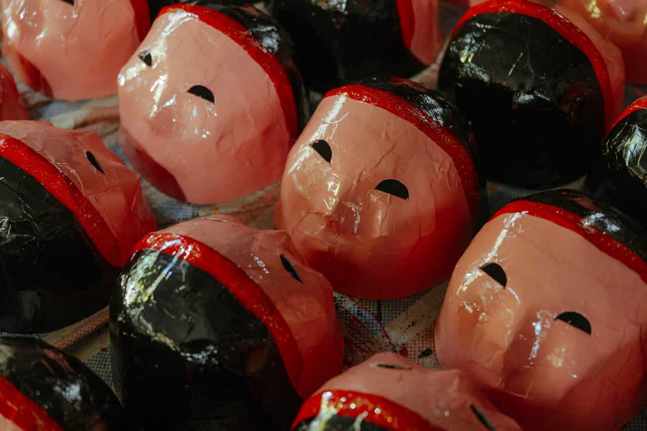 rows of masks colored in black, red and peach