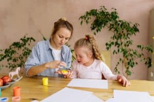 An aba therapist teaching the girl to paint