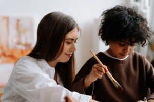 An applied behavior analyst ,teaching the kid to paint.