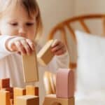 Yung child playing wooden blocks for spd testing