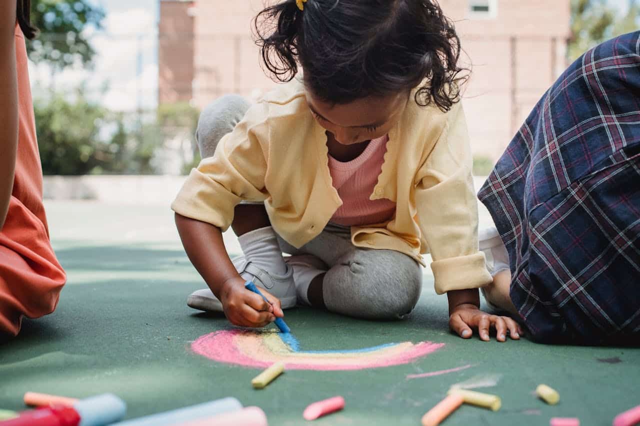 aba therapy and autism with girl making chalk art on pavement