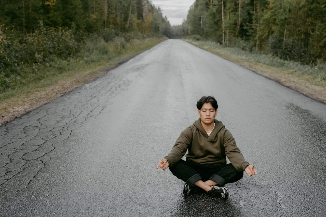 autistic man meditating in the middle of an empty road