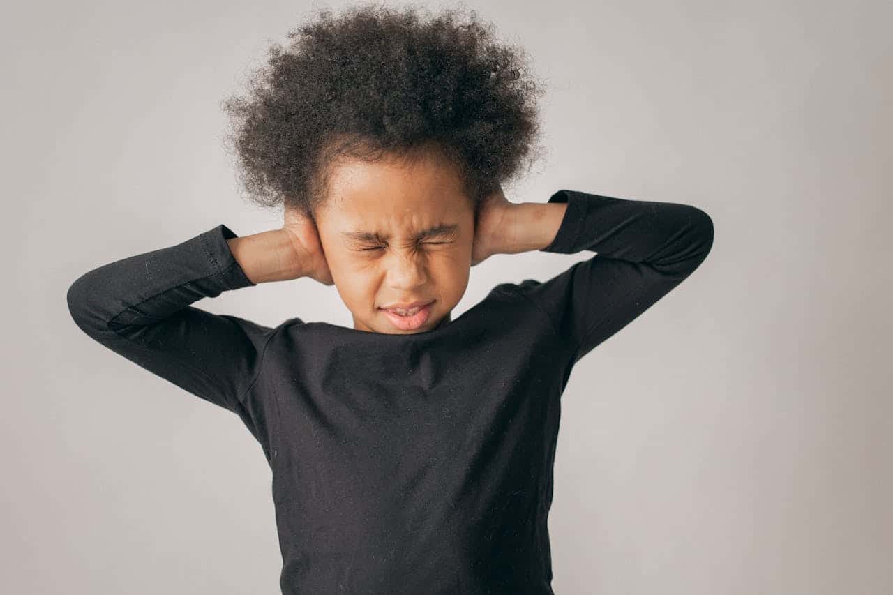 kid covering her ears as testing for spd