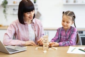 little girl and therapist building a wooden blocks