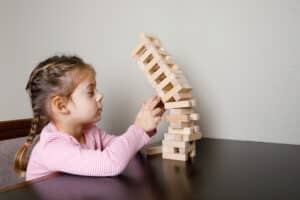 little girl playing wooden blocks during ABA Therapy session