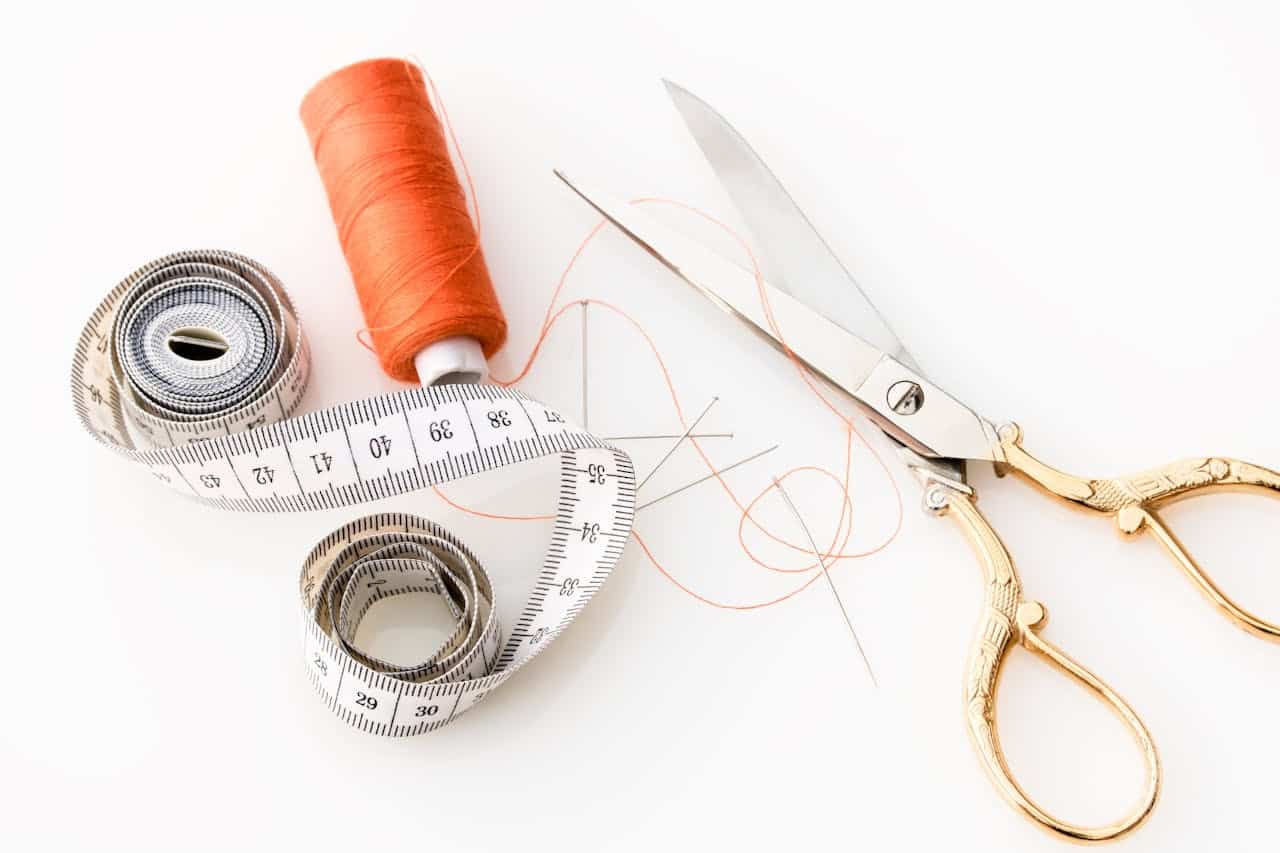 orange thread, tape measure, and fabric scissors