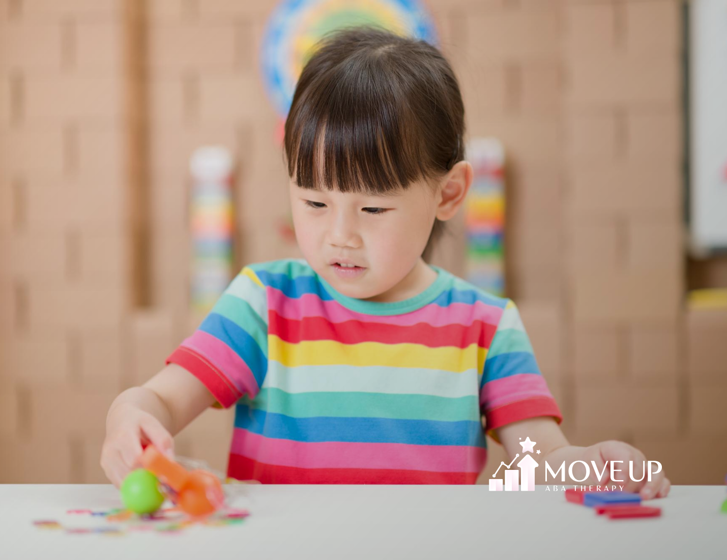 A kid with autism playing with toys on a table