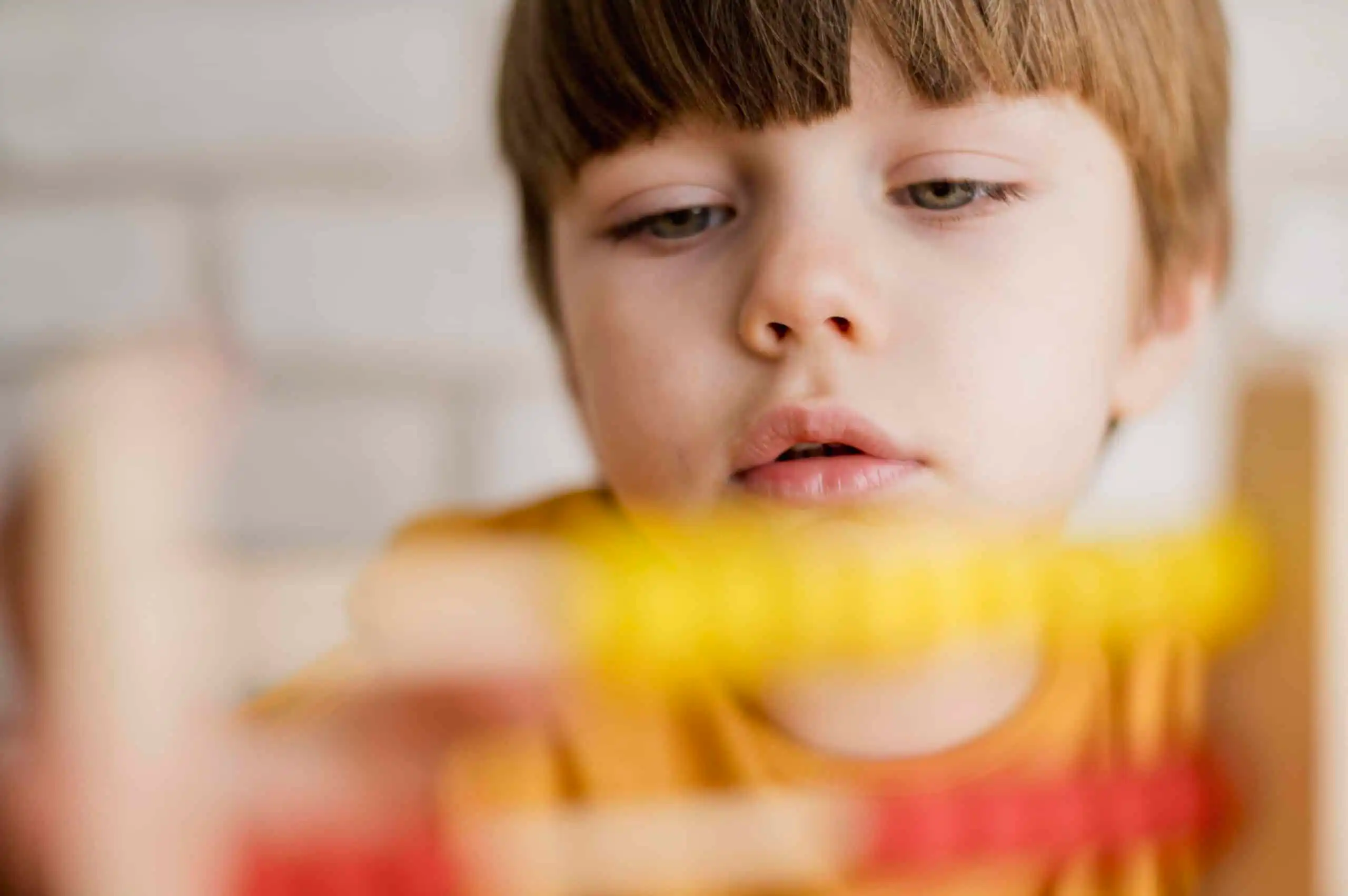 A boy with autism playing with a wooden toy