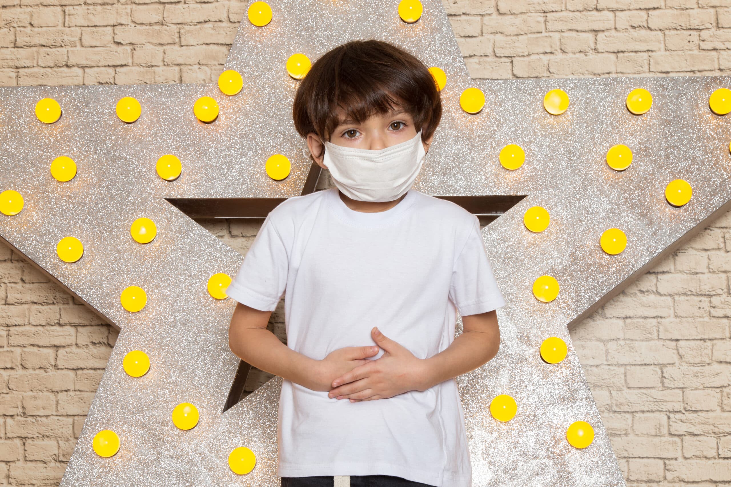 A kid with autism holding his painted hand up his eye