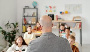 An RBT facing students with autism in a bright classroom during an ABA therapy session in Maryland.