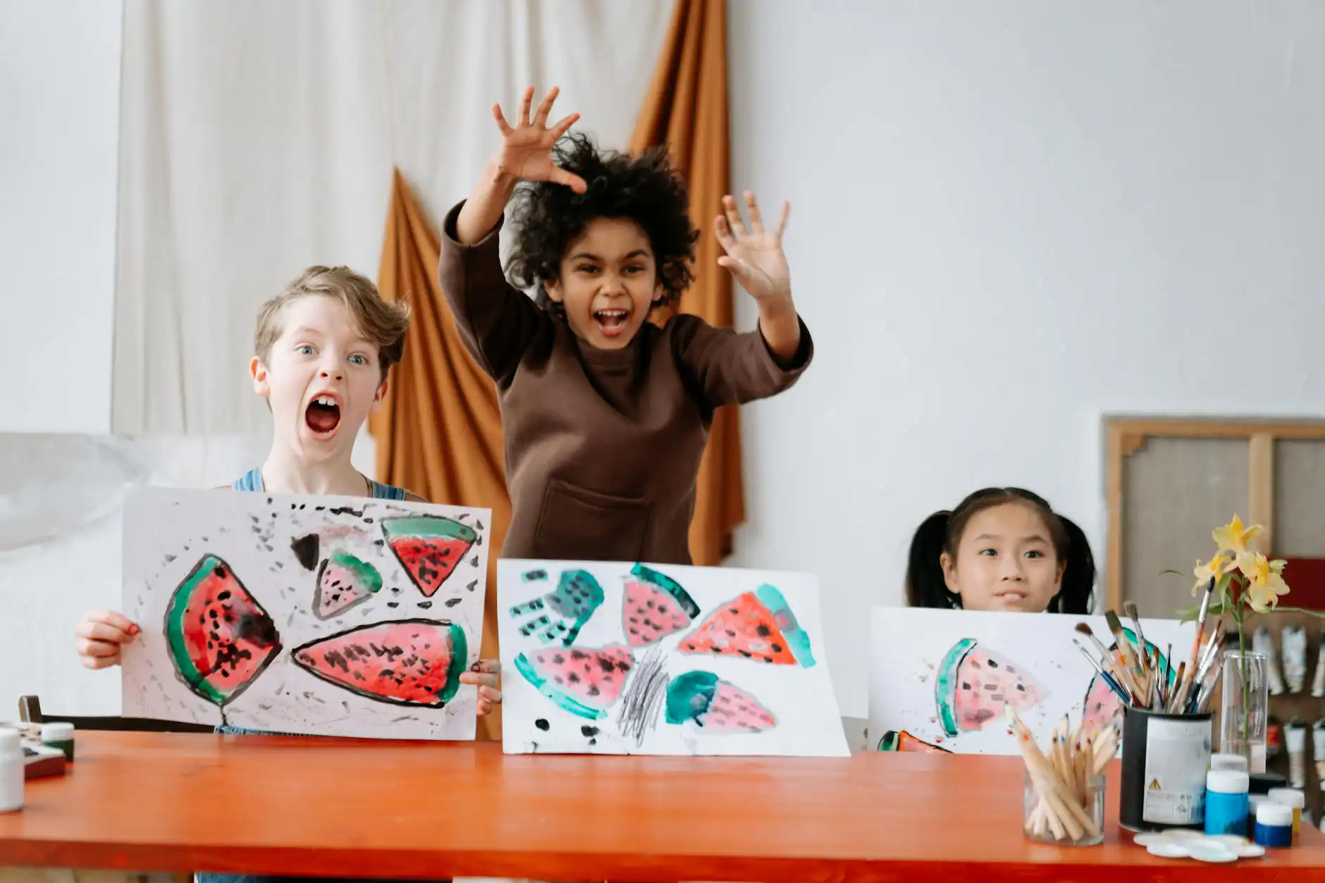 Autistic children smiling while excitedly showing their artwork in an autism school in Maryland.