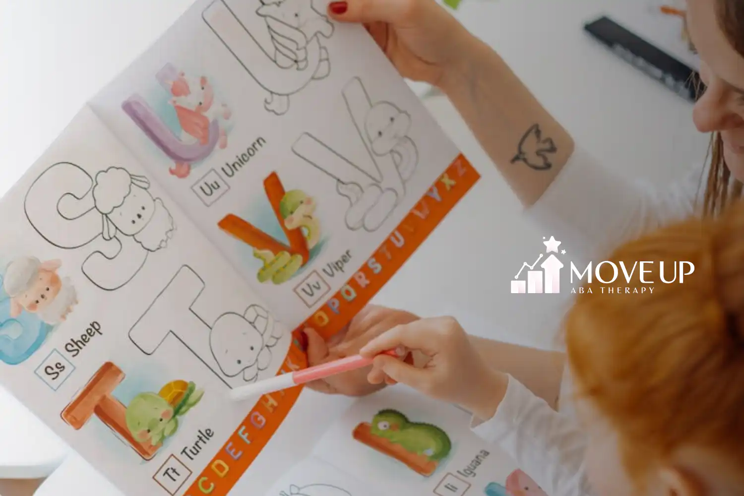 ABA therapist and autistic child pointing at letters at an illustrated alphabet learning book in MD.