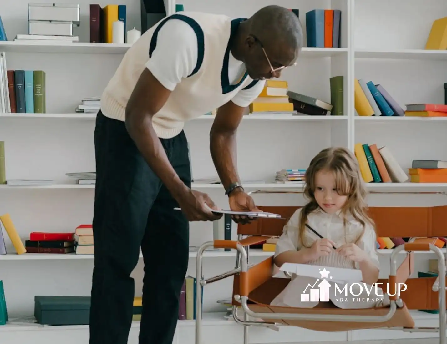 ABA therapist helping autistic girl with her work at a modern library classroom setting in Maryland.