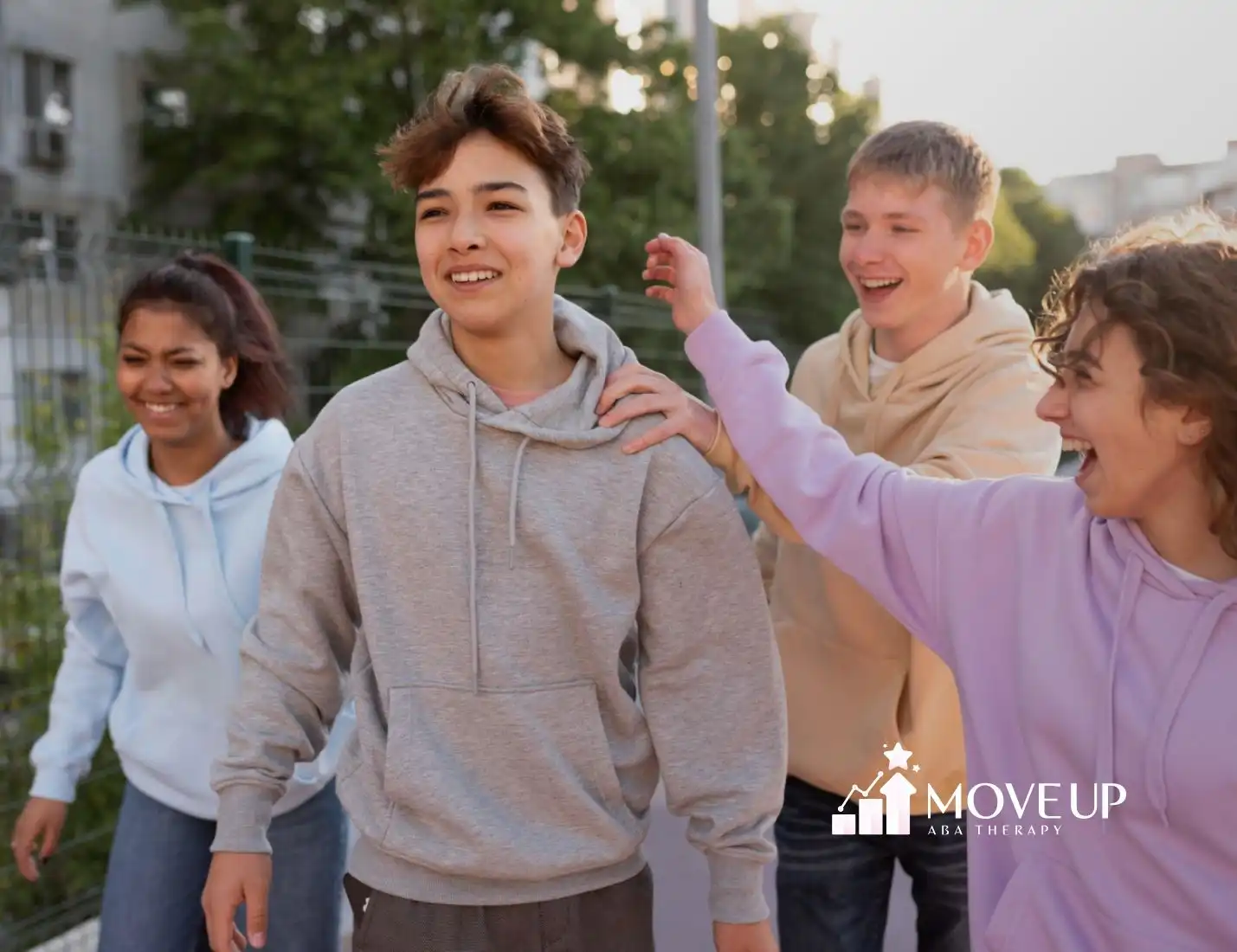 A group of four teenagers walking together outdoors.