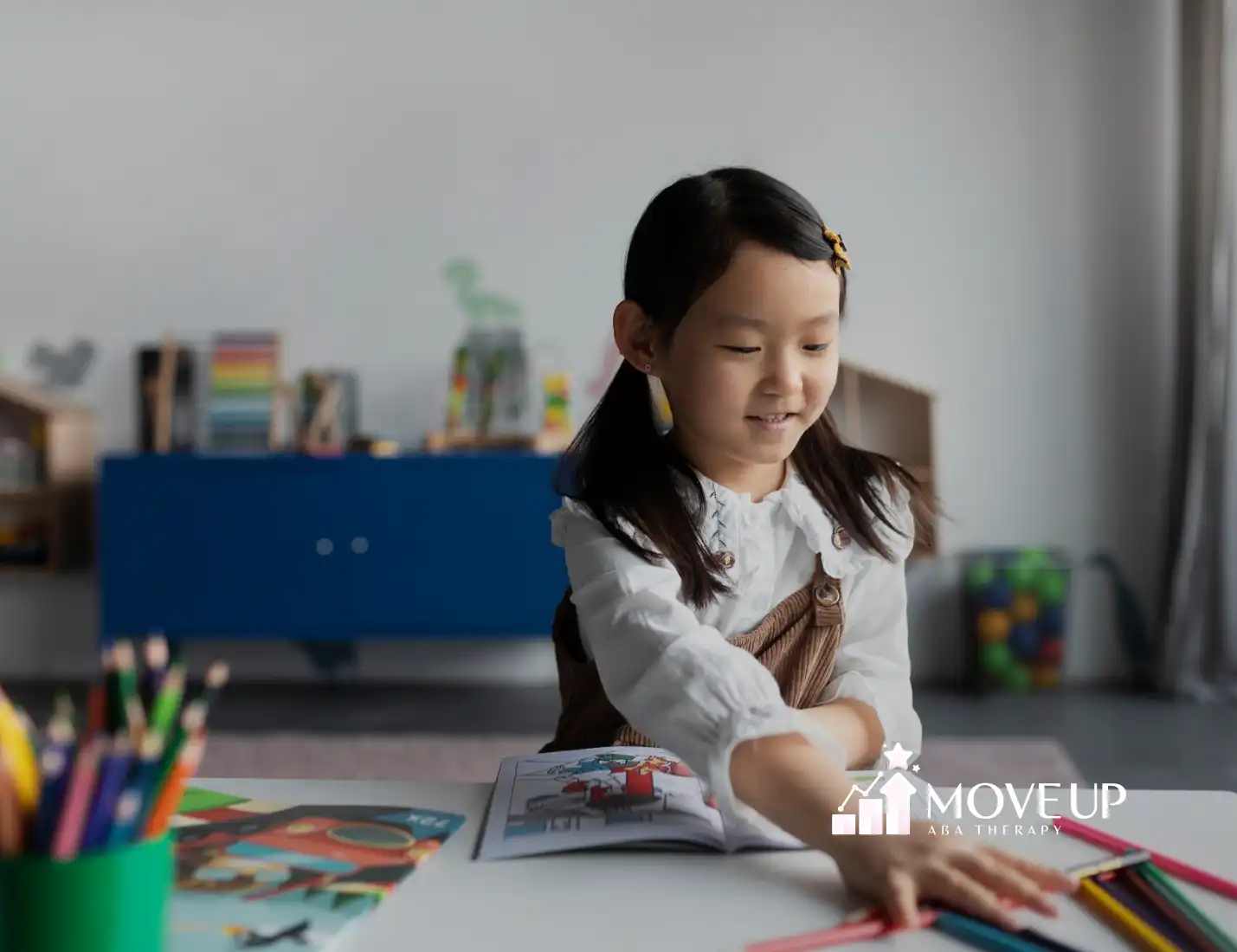 A girl with autism is coloring a paper on a table