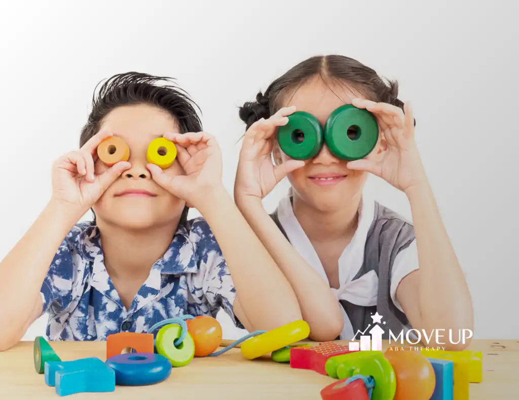 Two kids with autism holding colorful blocks