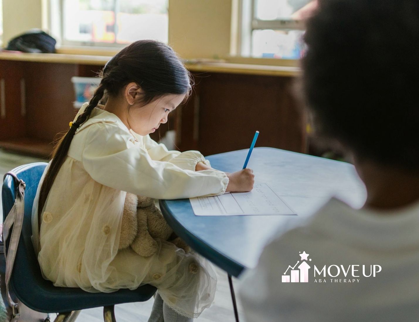 A young autistic girl is receiving ABA therapy at home from a certified ABA therapist.