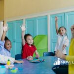 Autistic children raising hands in a classroom during a group activity with a teacher in Virginia.