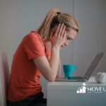 An autistic woman sitting at a desk having autism shutdown while using a laptop in Maryland.