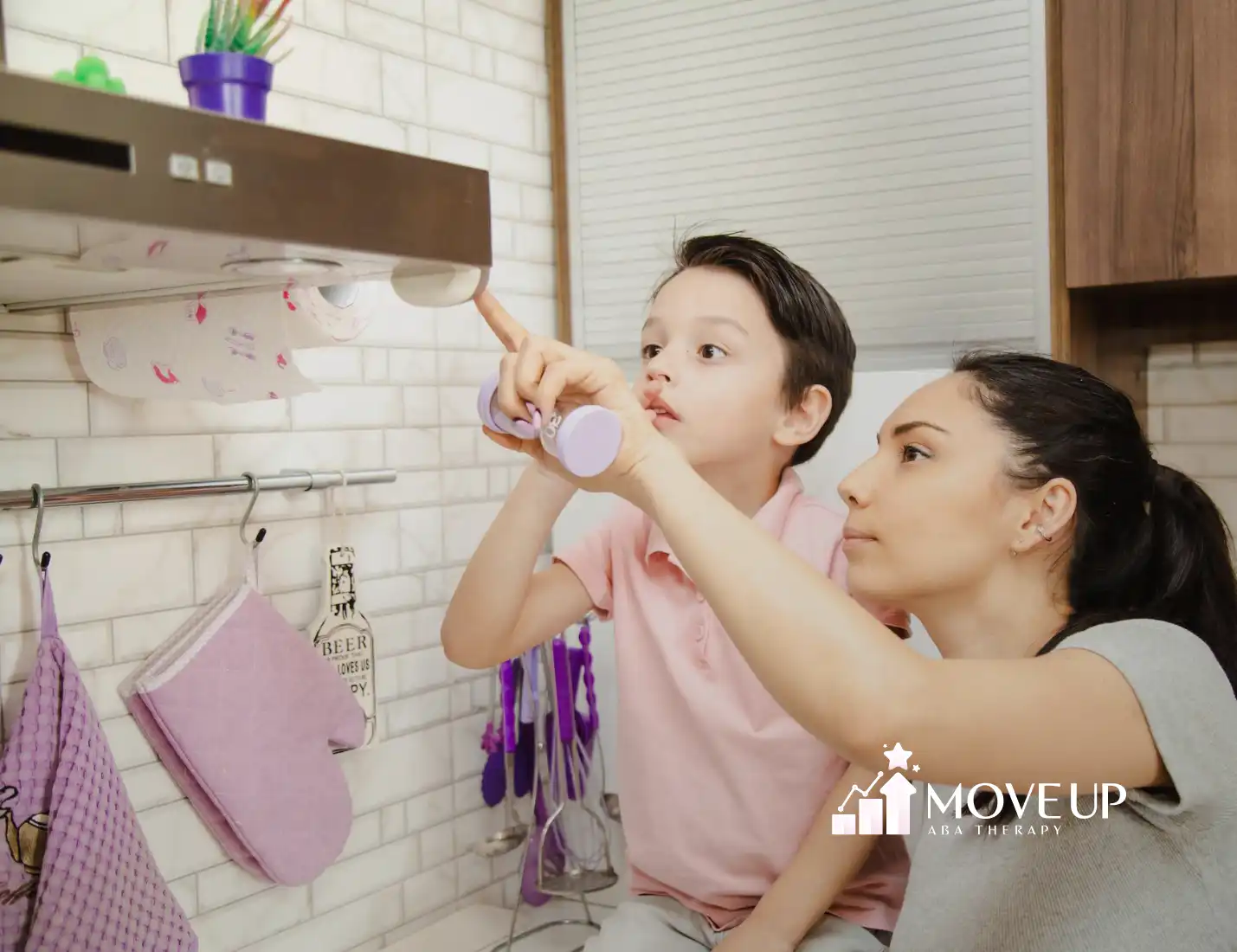 A mother and her child with autism is looking at a range hood in their kitchen