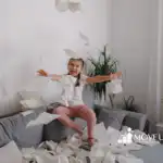 A girl throwing tissue papers in a living room