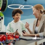 An RBT with her autistic student smiling while working together with robotics in a classroom during ABA therapy in VA.