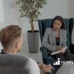 An ABA therapist listening attentively to his client while taking notes during a counseling session in Maryland.