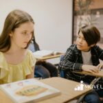 A boy talking to an autistic girl in a classroom while she looks away during a school-based ABA therapy in VA.