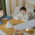 An ABA therapist showing a paper to two autistic children during an ABA therapy session at home in Virginia..