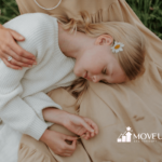 An autistic young girl resting peacefully with her head and t-rex arms on an RBT's lap outdoors in Maryland.