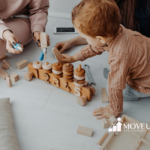 An autistic toddler playing with a wooden number toy and tools on the floor with adults during ABA therapy session in VA.
