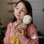 Young girl with autism hugging a stuffed bunny toy while looking thoughtful.