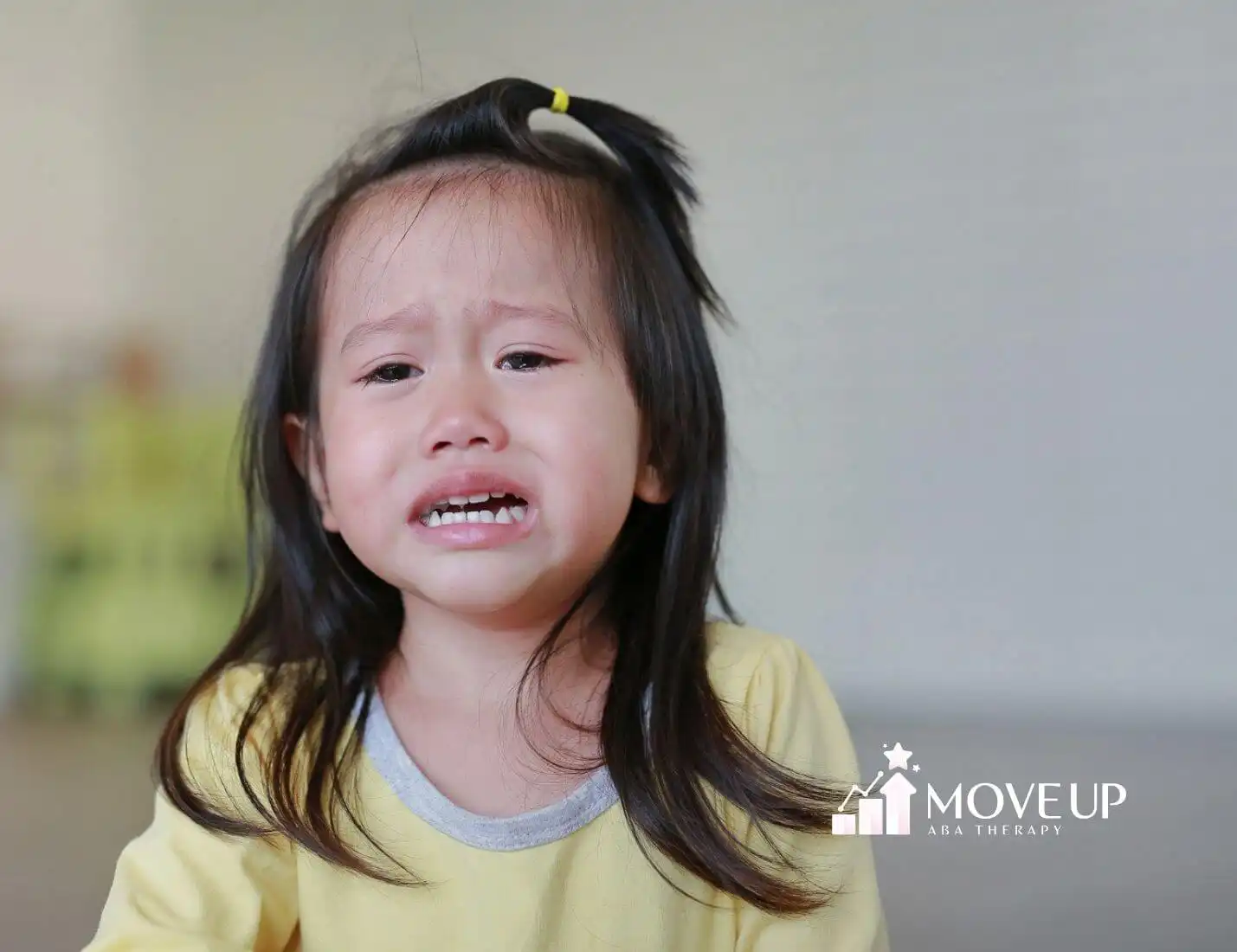 Autistic child experiencing a meltdown, supported through ABA therapy strategies.