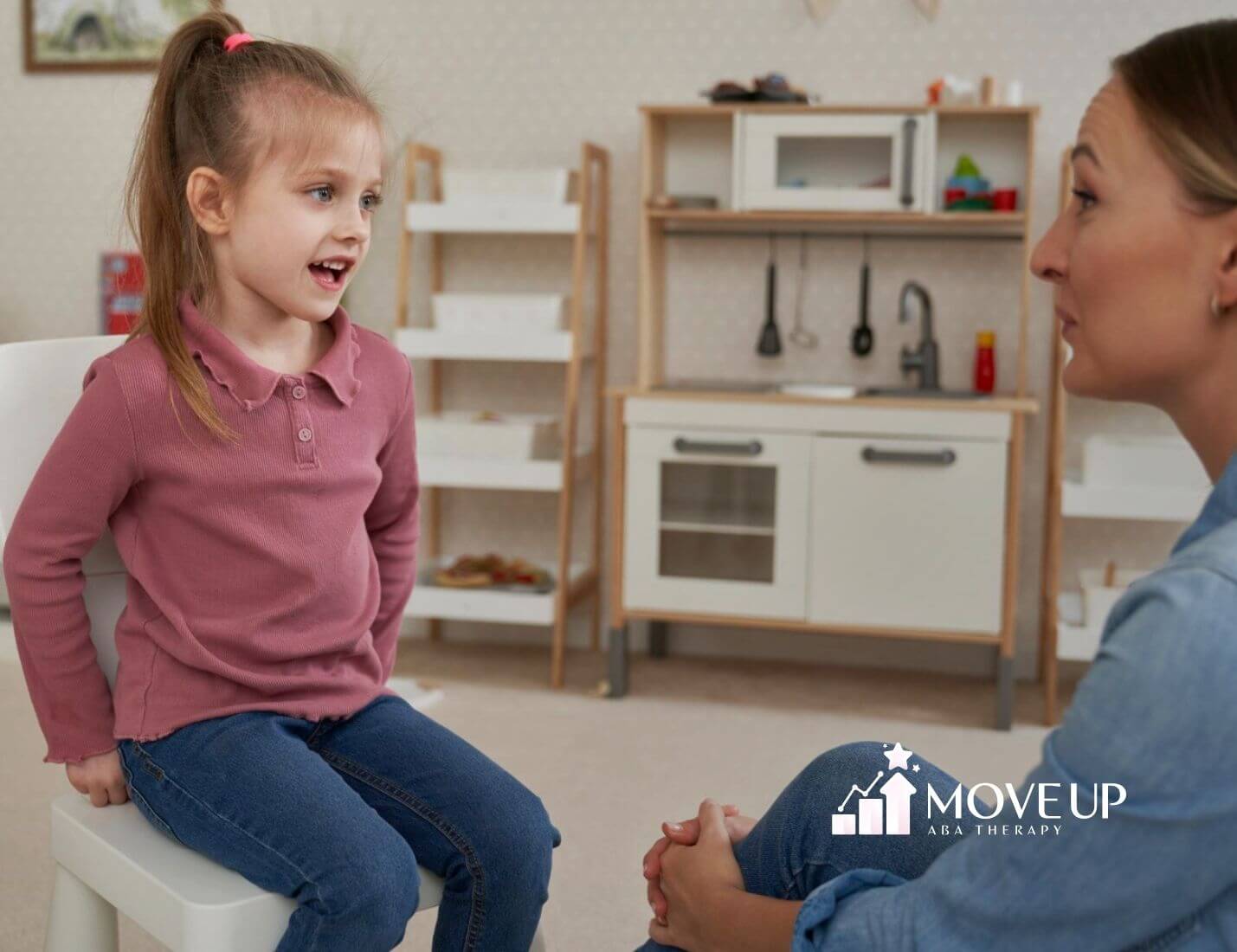 A BCBA sitting by a wall holding tissues and a cup, looking emotional during ABA therapy session in Virginia.
