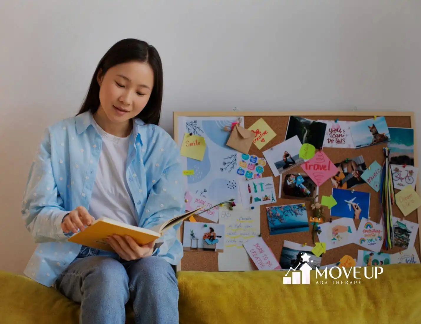 Young woman with autism reading notebook beside vision board with photos and notes.