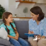 Female therapist conducting an in-home session with a young girl on a living room couch