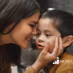 Mother tenderly cupping her son's cheek as they share a quiet, close interaction